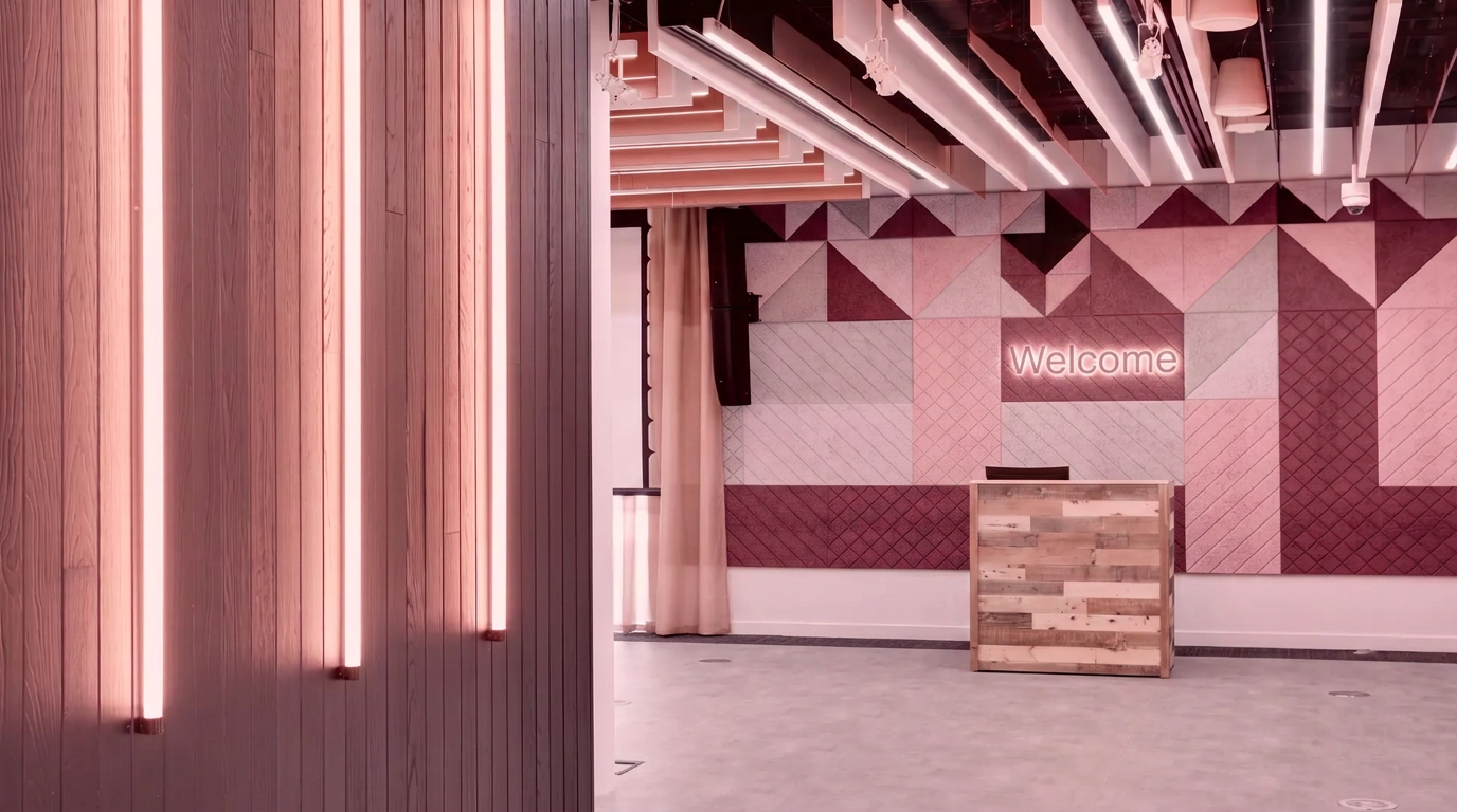 Blush-toned office reception with neutral illuminated Welcome signage